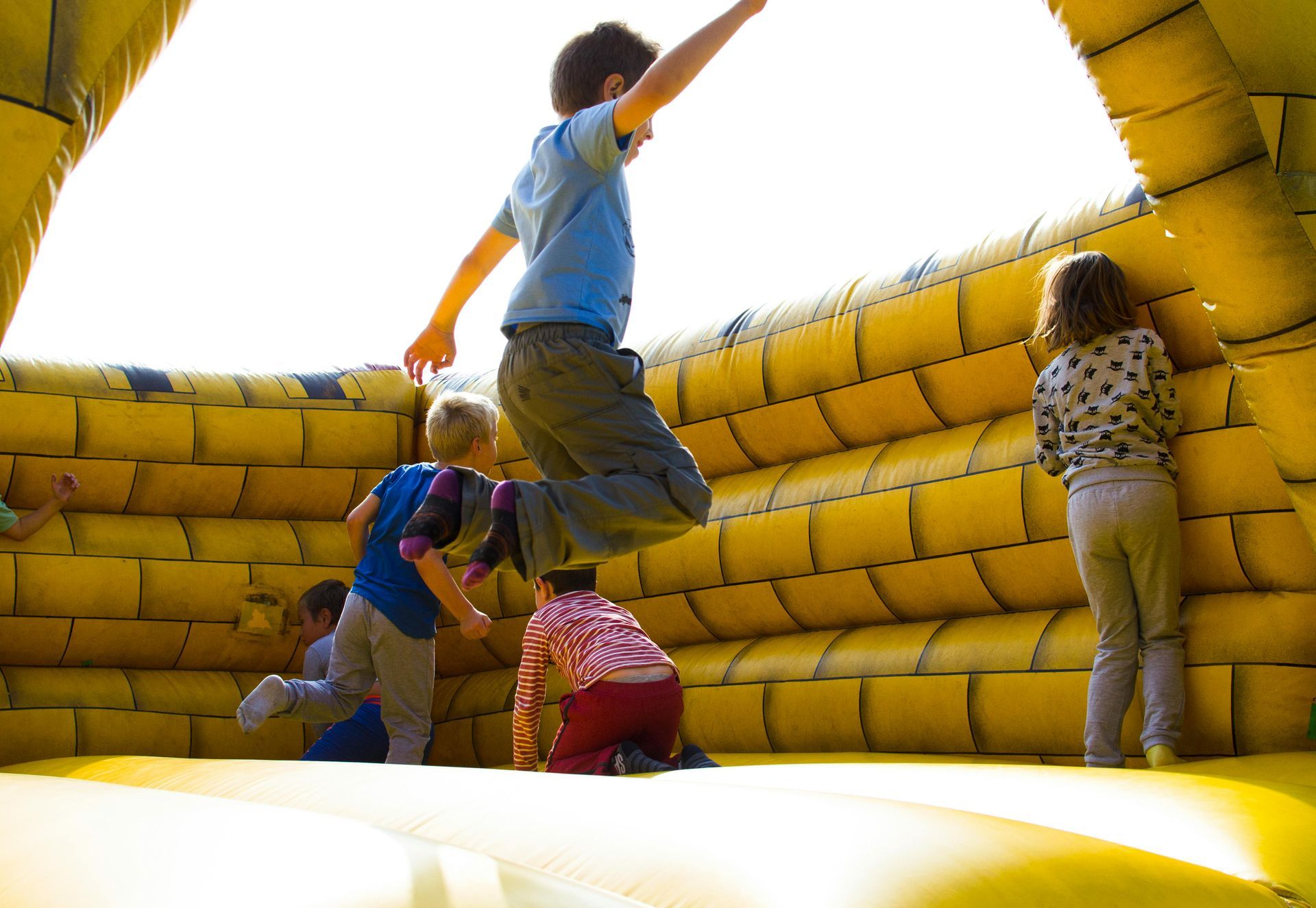 Children climbing on a yellow inflatable play structure outdoors